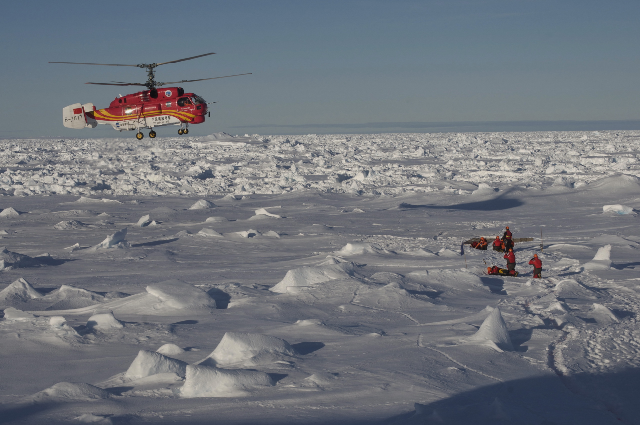 Helicopter above ridged sea ice with heavy snow cover.