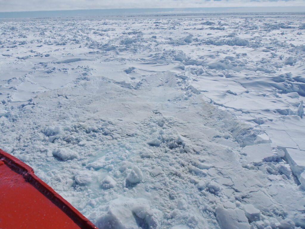 Ice-breaking ship ramming through rafted and snow covered first year sea ice. The ship moves back and forth to break through heavy sea ice. 