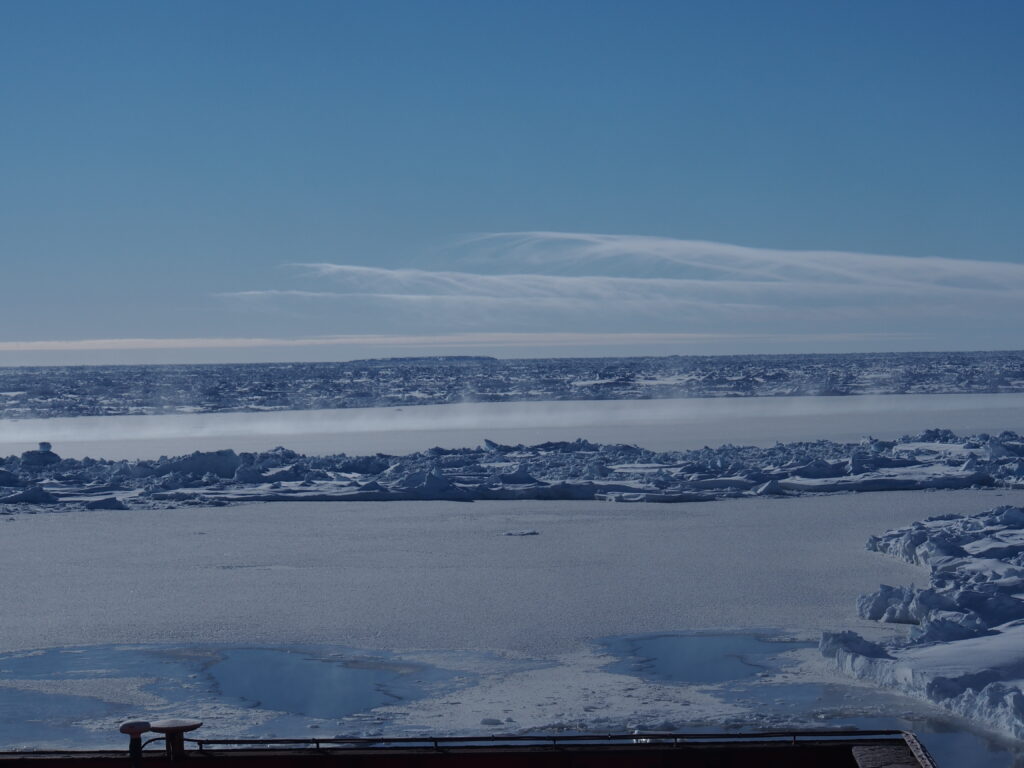 Pack ice viewed from a ship, with heat loss over open water and thin ice.