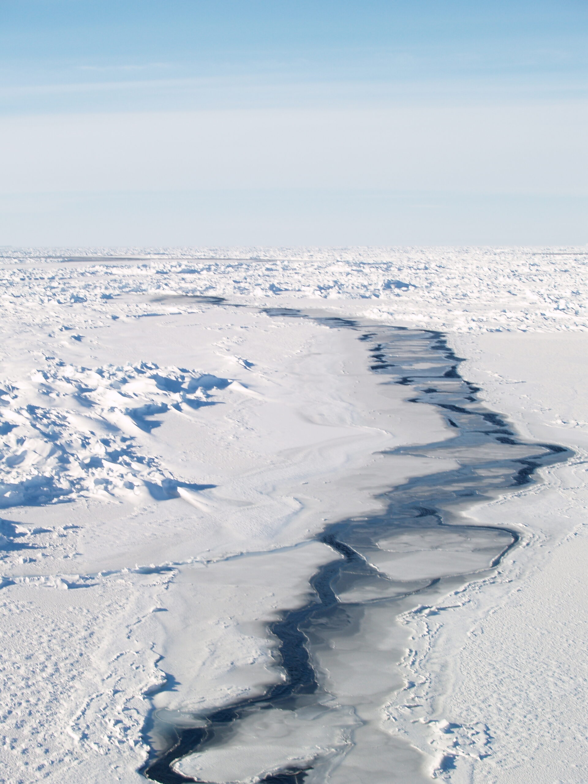 Open water lead through ridged first-year, snow-covered sea ice. The open water is freezing and rafting from nilas to grey ice.